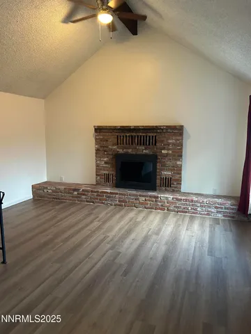 a view of empty room with wooden floor and fireplace
