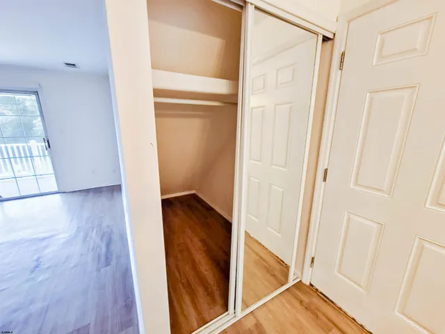 a view of a hallway with wooden floor and entryway