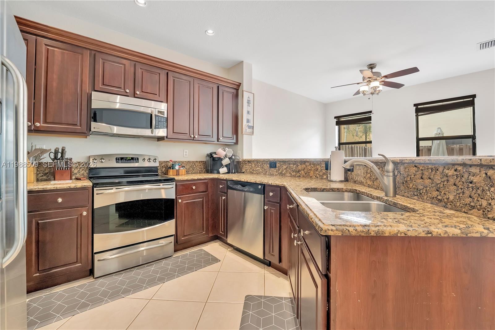 23484 Southwest 112th Court Homestead, FL 33032 - Photo 7 of 33 a kitchen with granite countertop a sink stainless steel appliances and cabinets