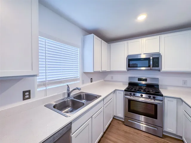 a kitchen with sink a microwave and cabinets