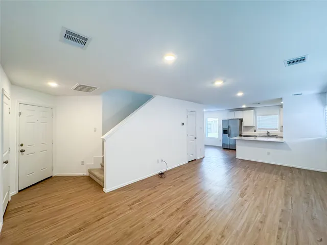 a view of a kitchen with wooden floor and a sink
