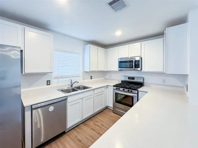 a kitchen with a sink stove top oven and cabinets
