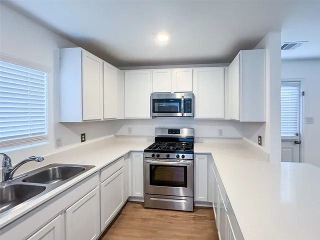 a kitchen with a sink a stove and cabinets