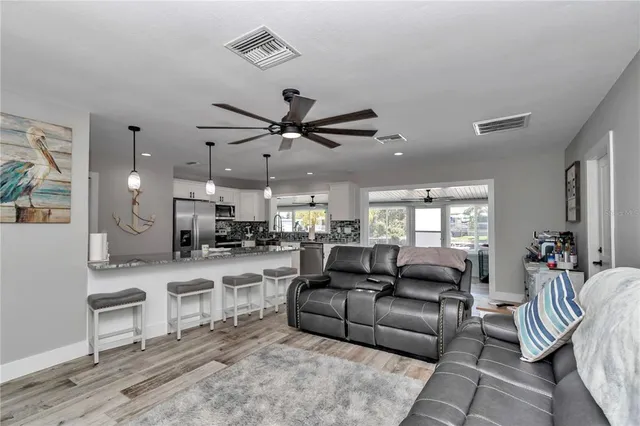 a living room with furniture kitchen view and a window