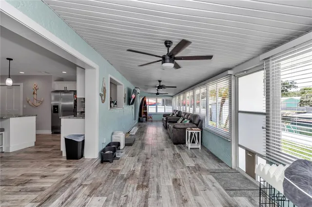 a view of a living room kitchen with furniture and a ceiling fan