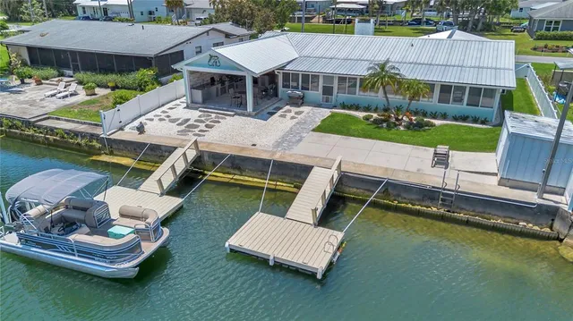 an aerial view of a house with swimming pool and outdoor seating