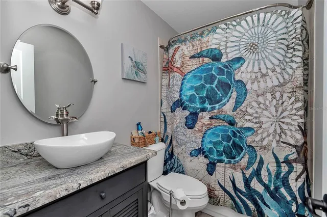 a bathroom with a granite countertop toilet sink and mirror
