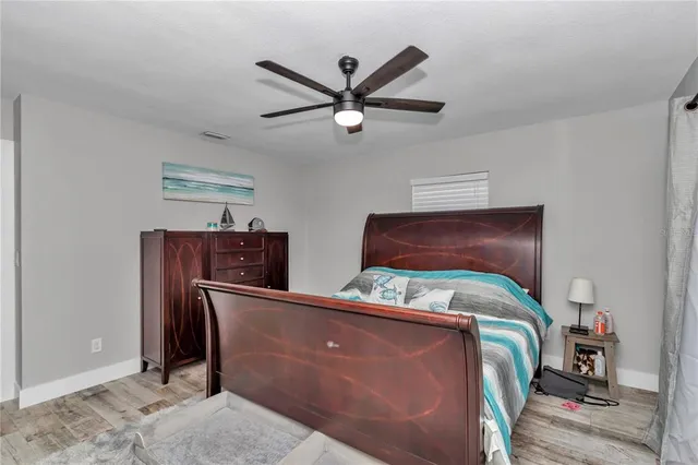 a bedroom with bed and wooden floor