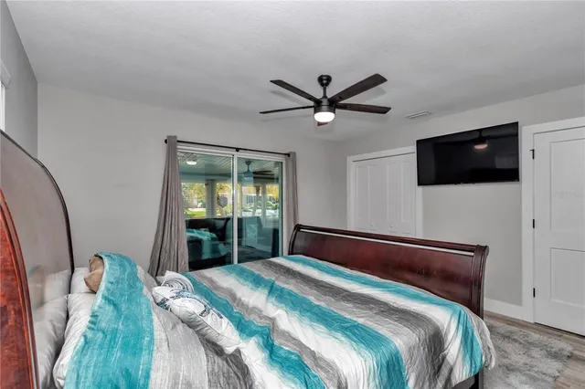 a bedroom with a large bed and a flat tv screen on dresser