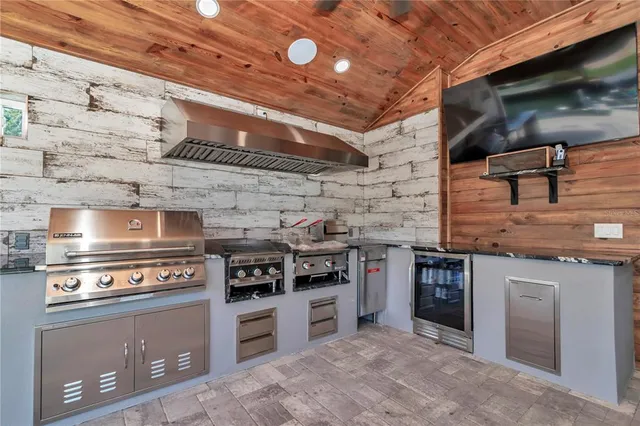 a view of a patio with couches chairs and wooden floor