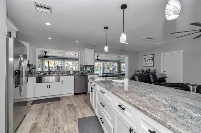 a large white kitchen with lots of counter space and refrigerator