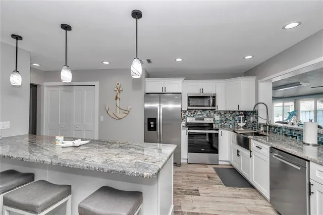 a kitchen with kitchen island granite countertop a stove and a center island