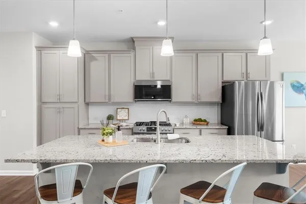a kitchen with granite countertop a sink a stove a refrigerator and a cabinets