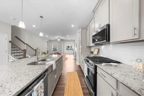 a kitchen with granite countertop stainless steel appliances lots of counter space and a sink