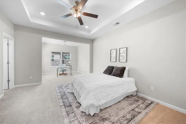 a bedroom with a large bed and a chandelier