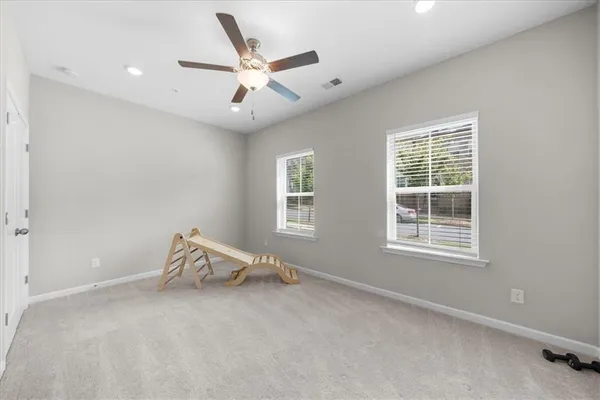 an empty room with windows and fan