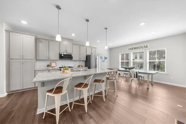 a view of a dining room and livingroom with furniture wooden floor a chandelier