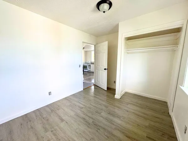 a view of an empty room with wooden floor