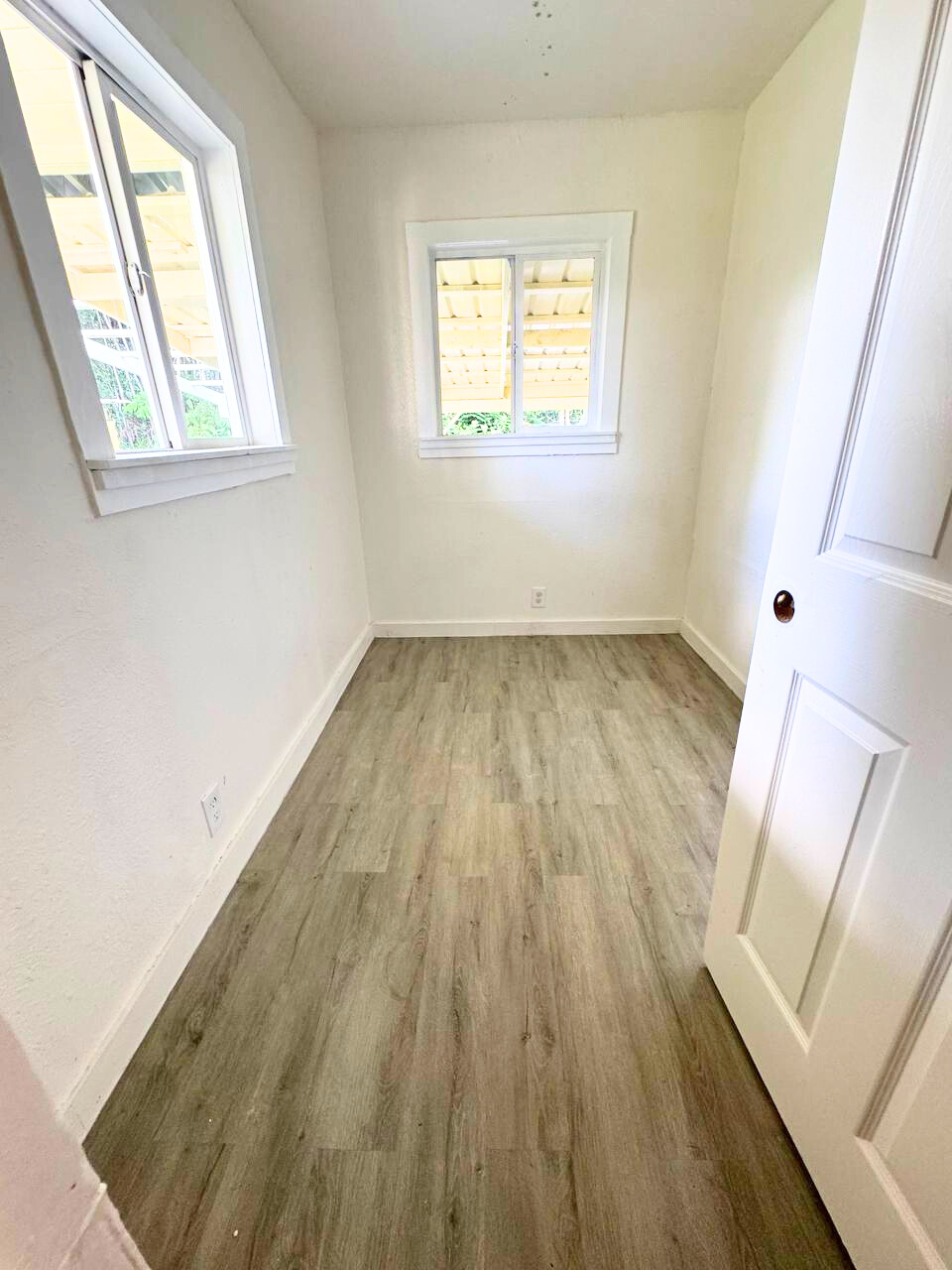 18-4069 Mauna Kea Drive Mountain View, HI 96771 - Photo 6 of 12 an empty room with wooden floor and windows