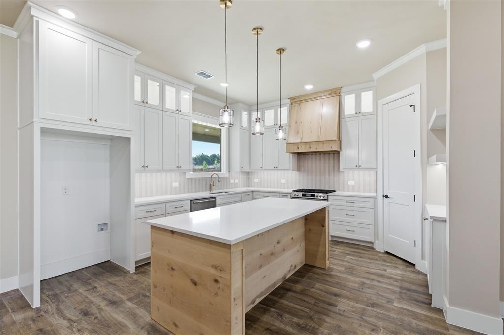 709 Anne Road Van Alstyne, TX 75495 - Photo 8 of 28 Kitchen featuring a wood-finish island with a white countertop, white shaker-style cabinetry, and wood-finish flooring