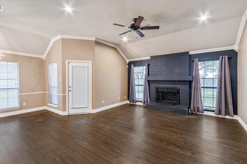 9508 Riviera Drive Waco, TX 76712 - Photo 6 of 24 a view of an empty room with wooden floor fireplace and a window