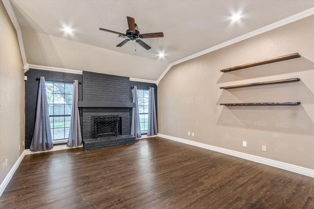 9508 Riviera Drive Waco, TX 76712 - Photo 8 of 24 a view of an empty room with wooden floor fireplace and a window