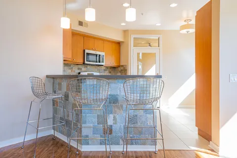 a kitchen with stainless steel appliances granite countertop a stove top oven a sink and a refrigerator