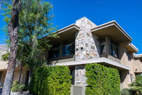 a front view of a house with garden and parking