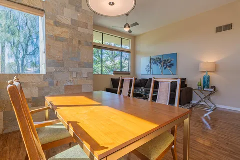 a view of a dining room with furniture a rug and wooden floor