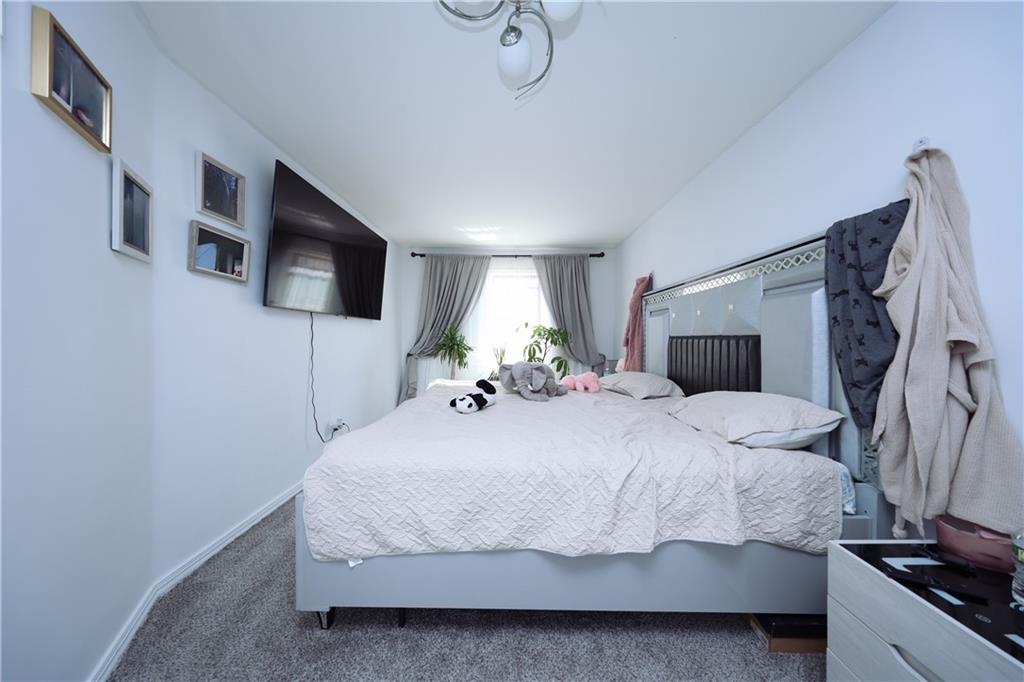 468 Ave Y Brooklyn, NY 11223 - Photo 34 of 47 a bedroom with a large bed and a flat tv screen on a dresser