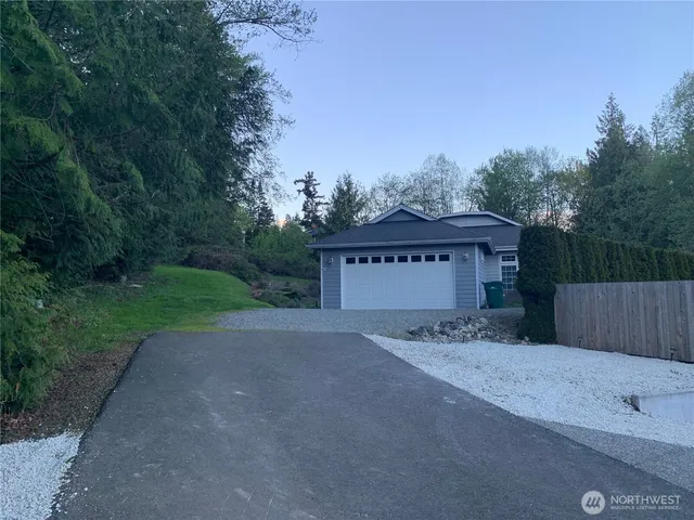 a view of a house with a small yard and wooden fence