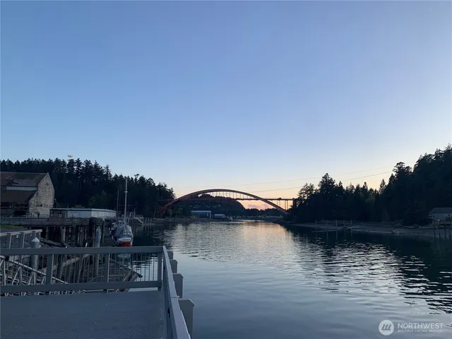 a view of a lake with outdoor seating space and barbeque oven