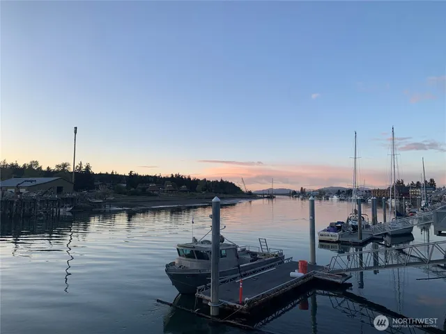 a view of a lake with lawn chairs and wooden floor