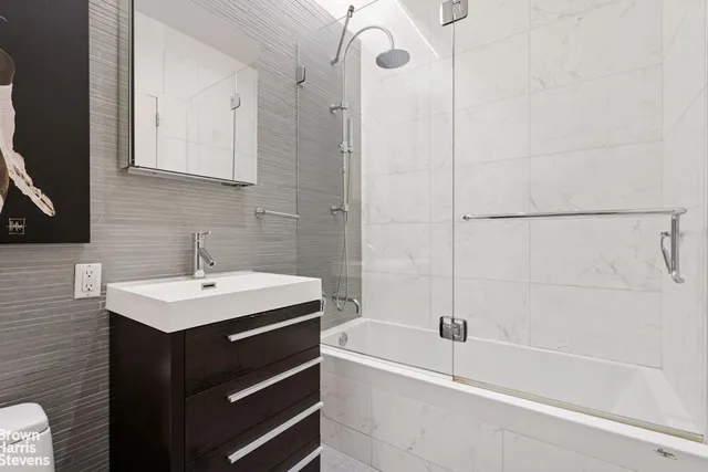 a bathroom with a sink vanity toilet and shower