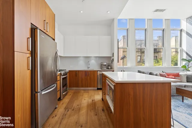 a kitchen with a sink a refrigerator and cabinets