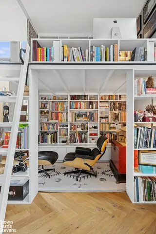a living room with furniture a book shelf and a book shelf