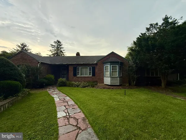 a front view of a house with a garden and yard