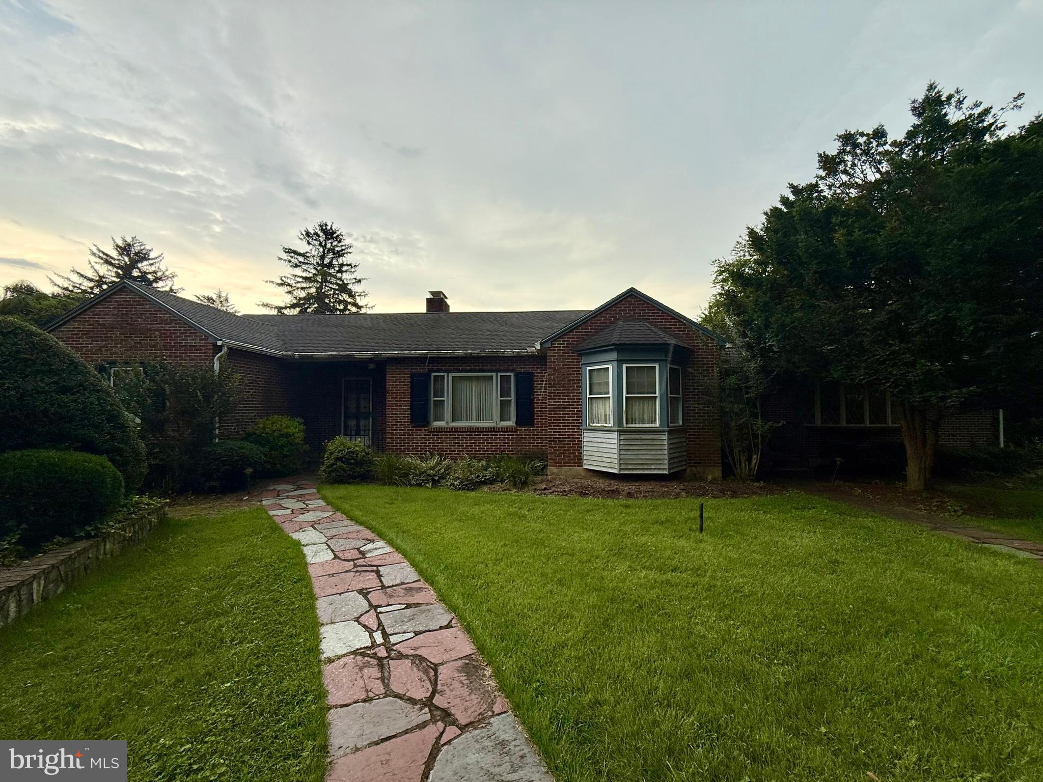 a front view of a house with a garden and yard