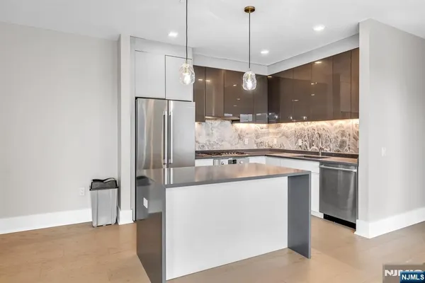 a kitchen with kitchen island a counter space a sink and stainless steel appliances