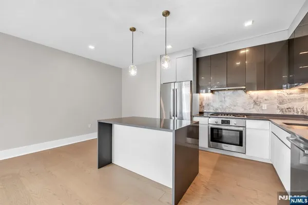 a kitchen with stainless steel appliances kitchen island a cabinets and a wooden floor