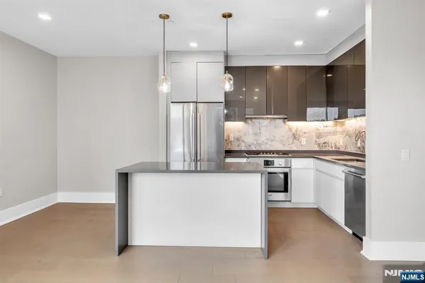 a kitchen with kitchen island a counter top space a sink and stainless steel appliances