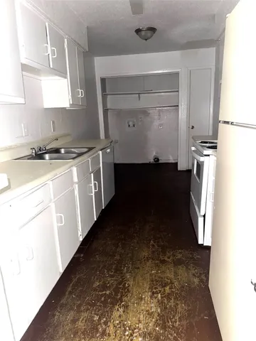 a kitchen with a sink a stove and a refrigerator