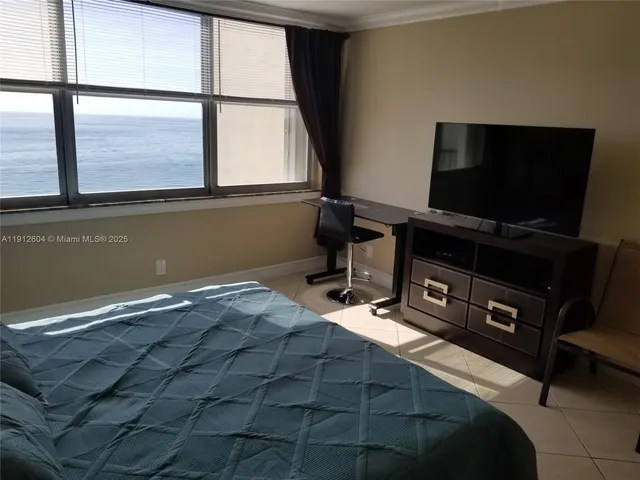 a living room with a bed furniture and a flat screen tv