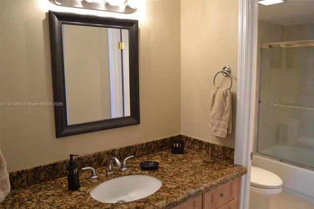a bathroom with a granite countertop sink and a mirror