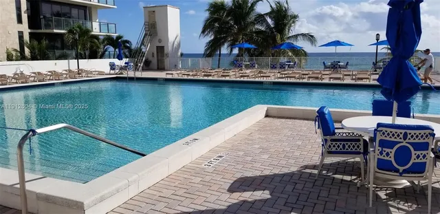 a row of palm trees and swimming pool in the backyard of a house