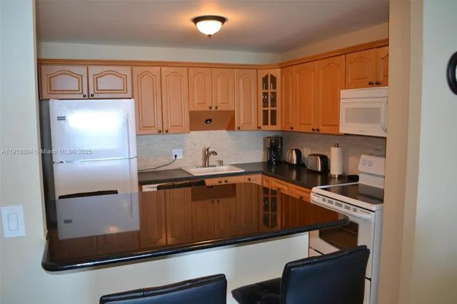 a kitchen with stainless steel appliances granite countertop a refrigerator and a stove