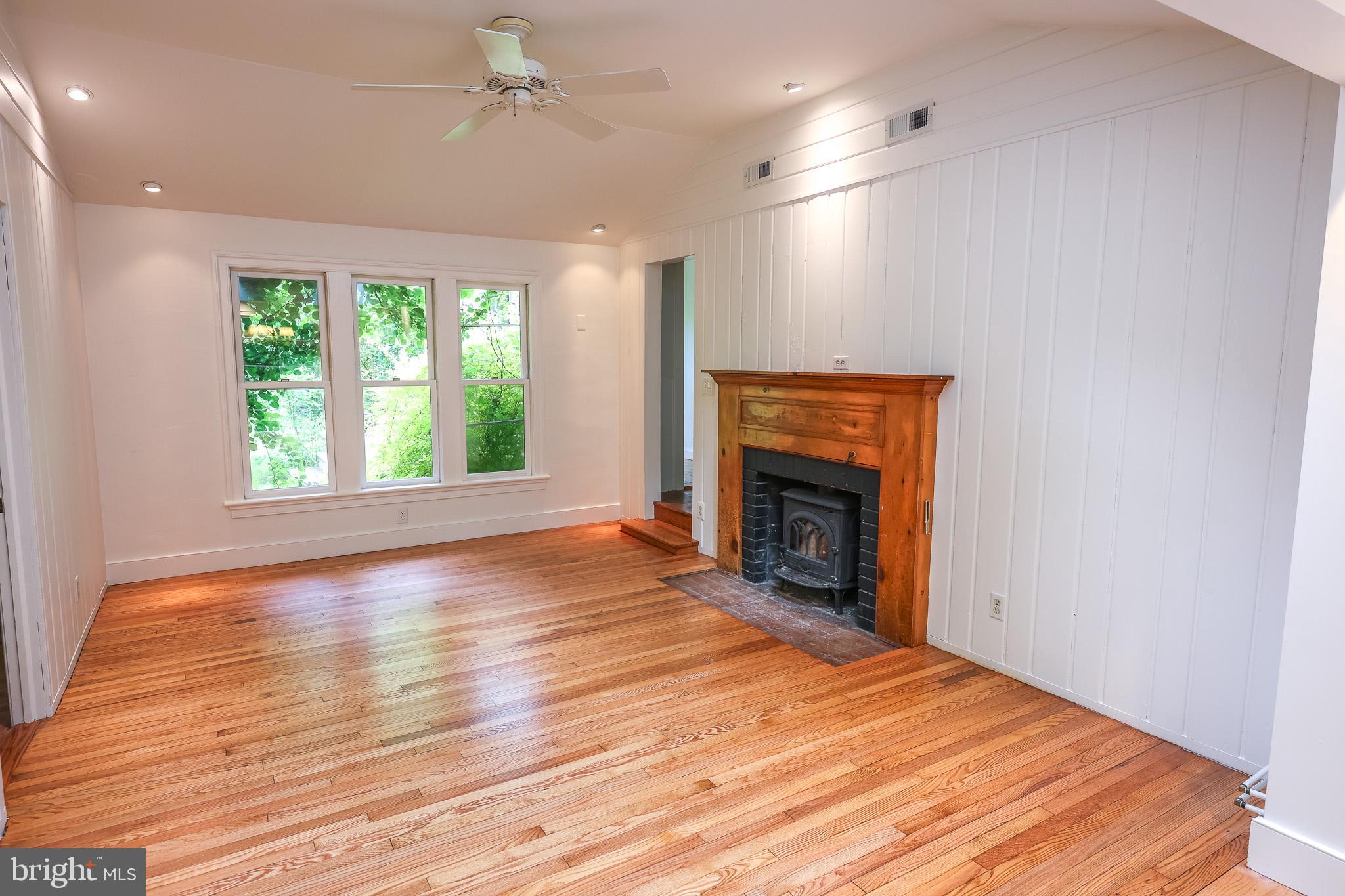 98 Swindler Hollow Road Sperryville, VA 22740 - Photo 6 of 25 an empty room with wooden floor fireplace and windows