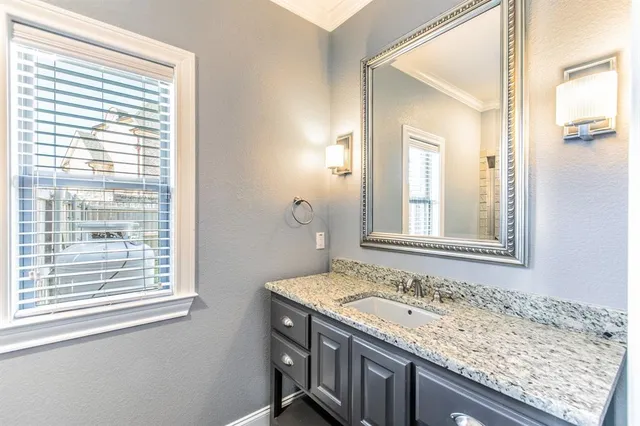 a bathroom with a granite countertop sink and a wooden cabinets