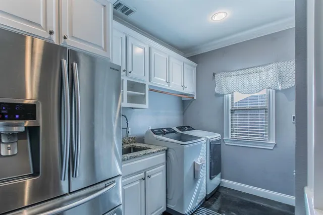 a kitchen with stainless steel appliances granite countertop a refrigerator a sink and a stove