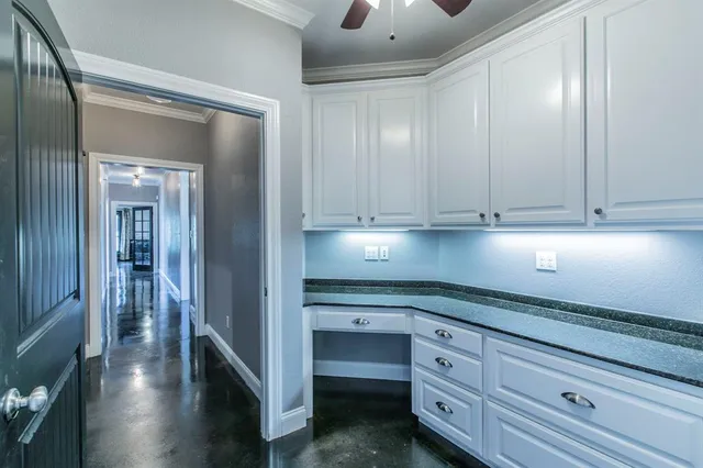 a kitchen with white cabinets and sink